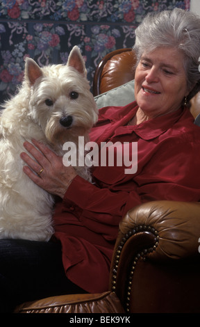ältere Frau, die Scottie Hund kuscheln, die ihr gleicht Stockfoto