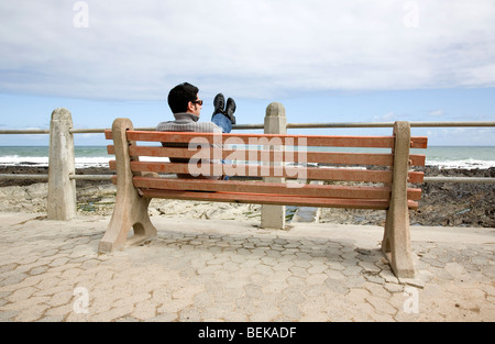 Mann sitzt auf der Bank auf Promenade Stockfoto