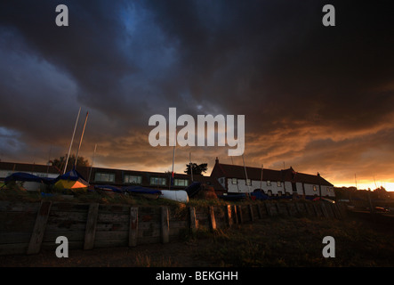 Dramatischen Sonnenuntergang Himmel über der Yachtausrüster an Burnham Overy Staithe auf die North Norfolk Küste, England, UK. Stockfoto