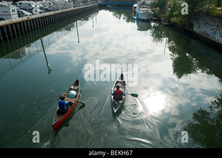 Kanufahrer aus dem Gowanus Bagger Kanuclub paddeln die verschmutzten Gowanuskanal in New YorK Stockfoto