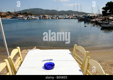 Tisch und Stühlen mit Blick auf den Hafen von Neos Marmaras ein Fischerdorf und Holiday Resort Nordgriechenland Stockfoto