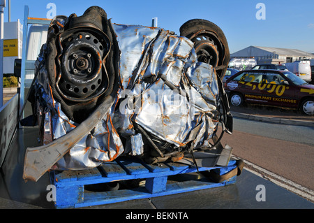 Verschrotteten Autos zerquetscht in einen Würfel für das recycling im Auto Händler Hof Teil der Regierung Verschrottungen Schema promotion Stockfoto