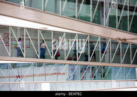 Flugpassagiere finden ihren Weg entlang der Stege aus ihrer neu ankommenden Flugzeuge in Richtung Ankunft Halle, Flughafen Heathrow. Stockfoto