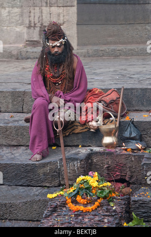 Pashupatinath, Nepal. Sadhu (Heiliger) in Nepals heiligsten Hindu-Tempel, auf die Stufen hinunter zum Fluss Bagmati. Stockfoto