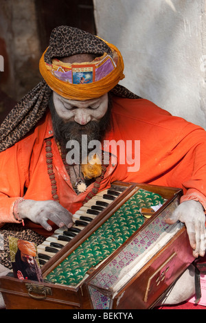 Pashupatinath, Nepal. Sadhu (Heiliger) am heiligsten Hindu-Tempel Nepals, Akkordeon-ähnlichen Instrument zu spielen. Stockfoto