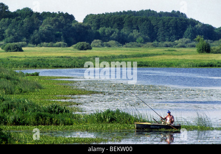 Mann Angeln vom Ruderboot am See in Sualki, Polen Stockfoto