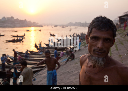 Mann steht neben Ruderboote am Fluss Buriganga in Dhaka Bangladesch Stockfoto