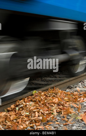 Zug Beschleunigung Vergangenheit Blätter liegen auf einem Gleis im Herbst in England. Stockfoto