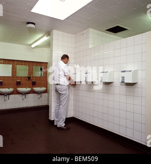 ein Mann mit Warmluft-Händetrockner in der öffentlichen Toilette Autobahn Stockfoto