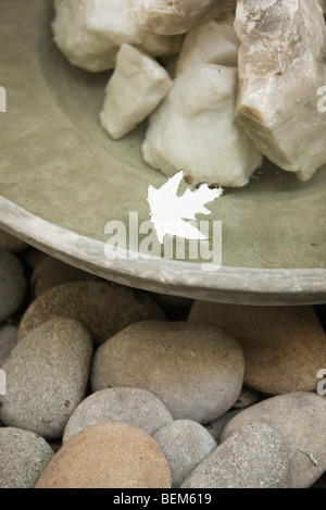 Blatt im Wasser fließt um Felsen in Brunnen Schale Stockfoto