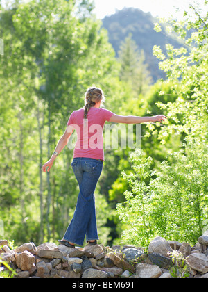 Frau zu Fuß auf Stein Barriere Stockfoto