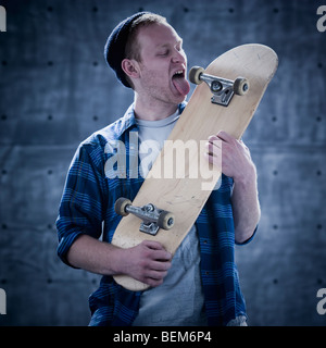 Männliche Skateboarder lecken board Stockfoto