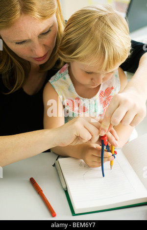 Frau helfen kleine Mädchen mit Kompass zeichnen Stockfoto