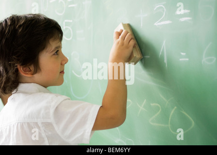 Kleine Junge löschen Klassenzimmer Tafel Stockfoto