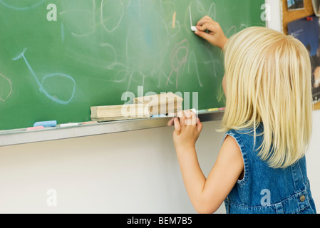 Kleines Mädchen auf Tafel zeichnen Stockfoto