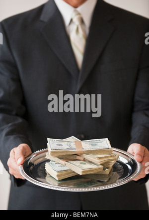 Geld auf Silbertablett Stockfoto