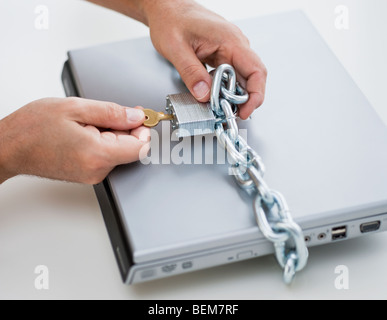 Hände, die Platzierung von Schloss und Kette auf computer Stockfoto