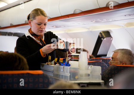 Flugbegleiter / Luft Stewardess serviert Getränke und Snacks für Passagiere von einem Wagen Karren während einem Easyjet Flug Stockfoto