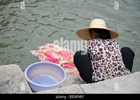 Chinesische Frau Händewaschen Tuch im Kanalwasser Xitang ist eine alte malerische Stadt in Jiashan County, Provinz Zhejiang, China. Stockfoto