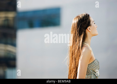 Frau mit langen Haaren stehen im Freien, Augen geschlossen, seitliche Ansicht Stockfoto