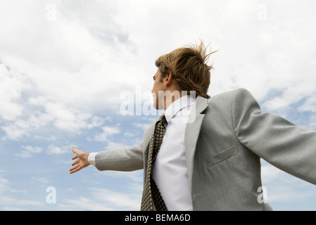 Geschäftsmann in Richtung Himmel erreichen Stockfoto