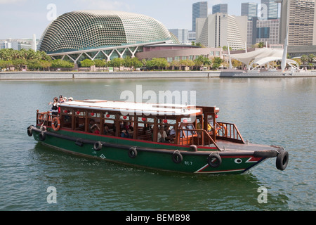 Ein Ausflugsschiff am Singapore River vor Esplanade - Theater an der Bucht (aka "The Durian") in Singapur Stockfoto