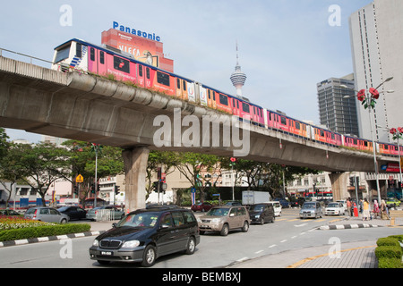 Eine Kreuzung mit einem RapidKL Zug Reisen auf einer Hochbahn in der Innenstadt von Kuala Lumpur, Malaysia. Stockfoto