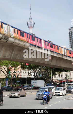 Eine Kreuzung mit einem RapidKL Zug Reisen auf einer Hochbahn in der Innenstadt von Kuala Lumpur, Malaysia. Stockfoto