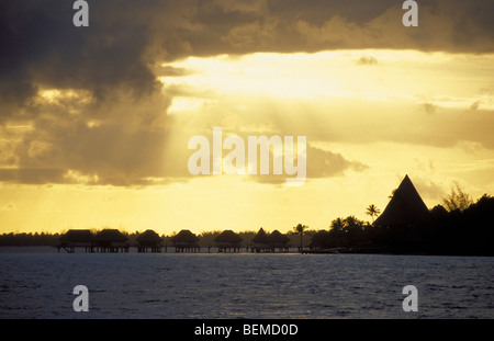 Kleine Strohhütten im Sonnenuntergang an der Küste. Bora Bora. Französisch-Polynesien. Stockfoto