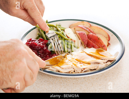 Hände des Mannes einen leckeren Truthahn für Thanksgiving oder andere Mahlzeit essen. Stockfoto