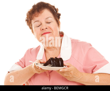 Kellnerin atmet den Geruch von Schokolade Kuchen vor dem Servieren mit einem Kunden. Isoliert auf weiss. Stockfoto