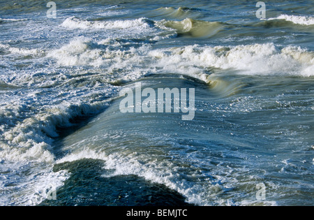 Wellen brechen über Wellenbrecher / Maulwurf / Leiste / Buhne am Strand entlang der Nordseeküste Stockfoto