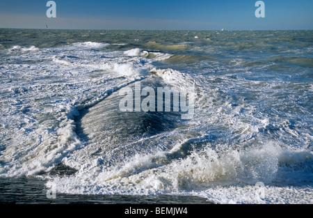 Wellen brechen über Wellenbrecher / Maulwurf / Leiste / Buhne am Strand entlang der Nordseeküste Stockfoto