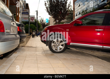 Rücksichtslose Fahrer Parks rote Auto teilweise auf dem Bürgersteig Stockfoto