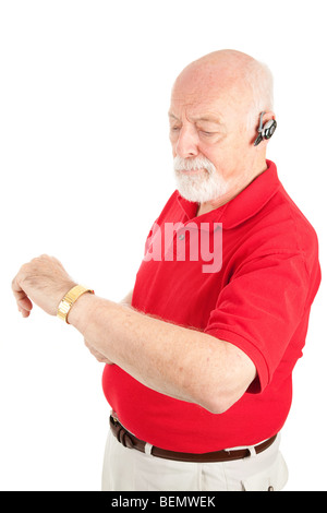 Ältere Mann auf seine Hände frei sprechen prüft seine Uhr. Isoliert auf weiss. Stockfoto