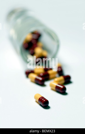 Medizin-Tabletten und Pillen strömte aus Schnapsglas hautnah Stockfoto