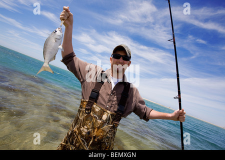 Fischer hält seinen Fang Stockfoto