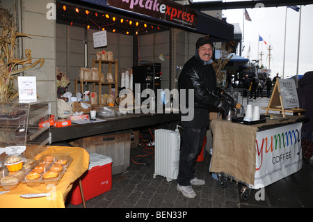 Gegen die Kälte gebündelt, verkauft ein Verkäufer Kaffee und Muffins in der South Street Seaport in Lower Manhattan. Stockfoto