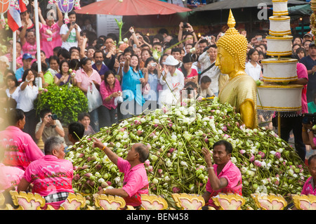 Massen werfen Lotusblumen auf eine Buddha-Statue auf dem Rap Bua Lotus werfen Festival in Thailand feiert das Ende der buddhistischen Stockfoto