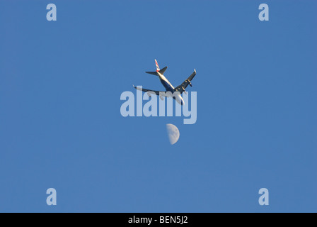 Flugzeuge im Himmel mit Mond im Hintergrund Stockfoto