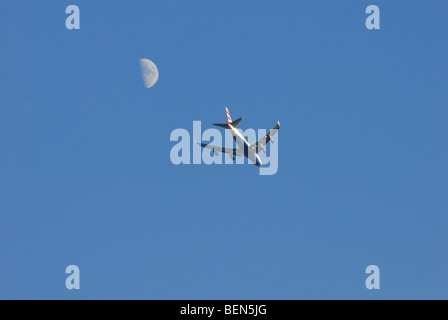 Flugzeuge im Himmel mit Mond im Hintergrund Stockfoto