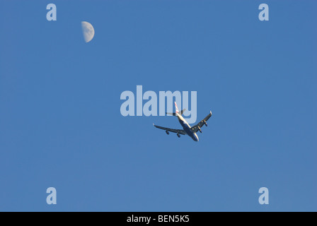 Flugzeuge im Himmel mit Mond im Hintergrund Stockfoto