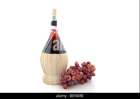 Korb-Flasche mit Chianty und Weintrauben aus Italien über weiß Stockfoto