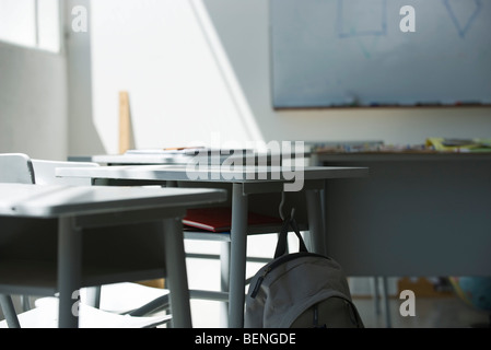 Schultasche von Schreibtisch im leeren Klassenzimmer hängen Stockfoto