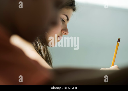 Teenager-Mädchen in der Klasse, Seitenansicht schreiben Stockfoto