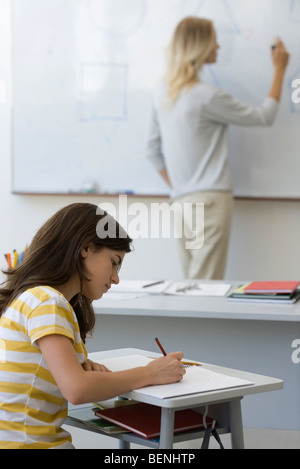 High-School-Schüler Notizen als Lehrer schreibt am whiteboard Stockfoto