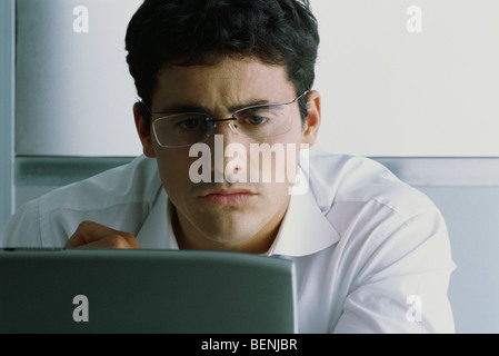 Mann mit Computer, runzelt die Stirn Stockfoto