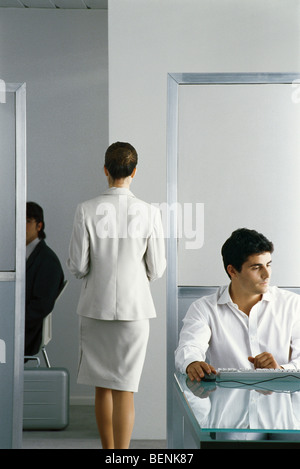 Weibliche executive zu Fuß durch Büro während Kollegen arbeiten, Rückansicht Stockfoto