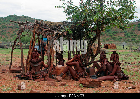 Himba-Frauen in traditionellen Dorf mit Lehmhütten, Kaokoland / Kaokoveld, Kunene-Region, nördlichen Namibia, Südafrika Stockfoto
