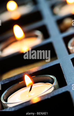 Brennende Kerzen in Glashaltern und Holz stehen Stockfoto